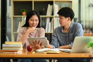 Proje üzerinde çalışan mutlu üniversite öğrencileri, kampüste birlikte sınava hazırlanıyorlar. Eğitim ve yaşam tarzı kavramı.