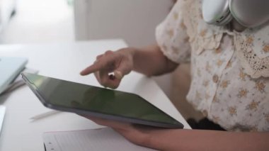 Tanımlanamayan bir kadın yeşil ekran dijital tableti aşırıyor. Teknoloji, iletişim ve eğitim kavramı.