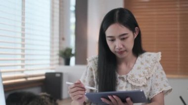 Genç iş kadınının iş yerinde dijital tablet kullanırken çekilen fotoğrafı..