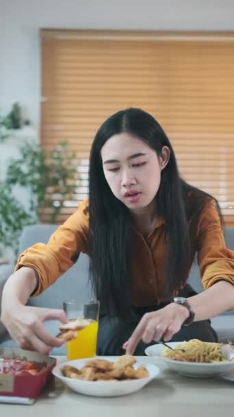 Pretty Młoda Azjatycka Kobieta Siedzi Kanapie Nowoczesnym Salonie Chciwie Jeść — Wideo stockowe