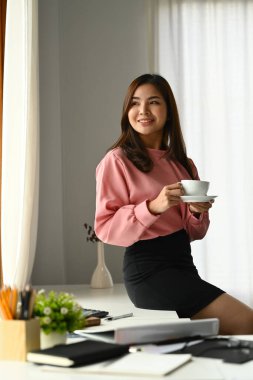 Harika bir milenyum girişimcisi sıcak kahve ya da çay içiyor, tatil zamanlarının tadını çıkarıyor..