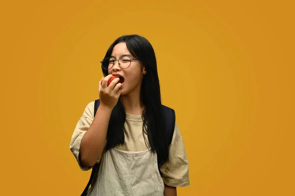 Immagine Carino Adolescente Asiatico Ragazza Mangiare Mela Isolato Sfondo Giallo — Foto Stock