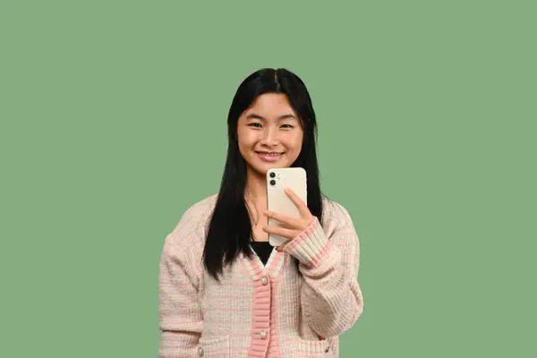 Yeşil Arka Planda Duran Akıllı Telefonlu Mutlu Genç Kız Nsanlar — Stok fotoğraf