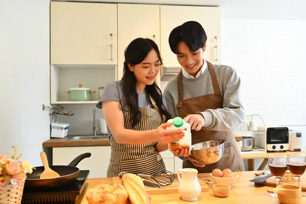 キッチンで新鮮な朝食パンケーキを作るために生地を準備する若いカップルを愛する — ストック写真