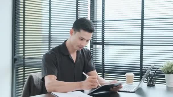 Angenehmer Junger Geschäftsmann Mit Stift Der Notizen Auf Digitalem Tablet — Stockvideo