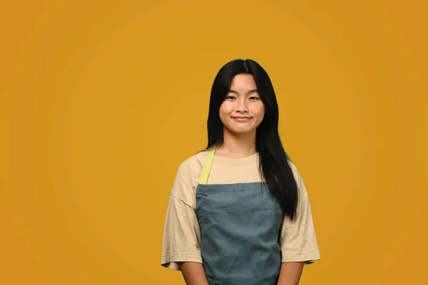 Sarı Arka Planda Önlük Giymiş Gülümseyen Asyalı Kadın — Stok fotoğraf