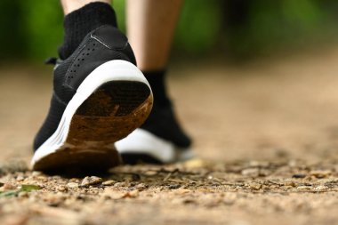 Yürüyüş botlu erkek bacakları orman yolunda yürüyor. Seyahat ve macera konsepti.