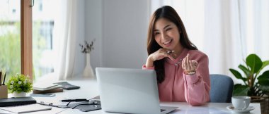 Çekici kadın finans danışmanı müşteriyle çevrimiçi sohbet ediyor, dizüstü bilgisayarla müşteriye internet danışmanlığı yapıyor..