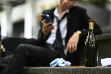 Çaresiz bir işadamıyla merdivenlerde bir şişe alkol. Kayıp, işsiz, alkolizm sorunu veya iflas.