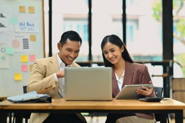 Erkek yönetici bilgiyi açıklıyor, iş planını genç bayan meslektaşımla tartışıyor..