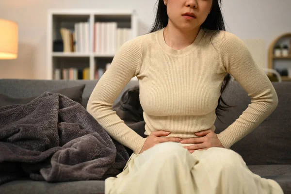 Chorą Młodą Kobietę Cierpiącą Ból Brzucha Podczas Siedzenia Kanapie Domu — Zdjęcie stockowe