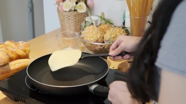 フライパンでスパチュラとパンケーキをフリッピングする若い女性のショット — ストック動画