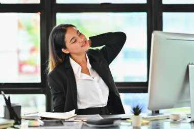 Bin yıllık iş kadını boynuna masaj yapıyor, ofis sandalyesinde yanlış durduğu için acı çekiyor..