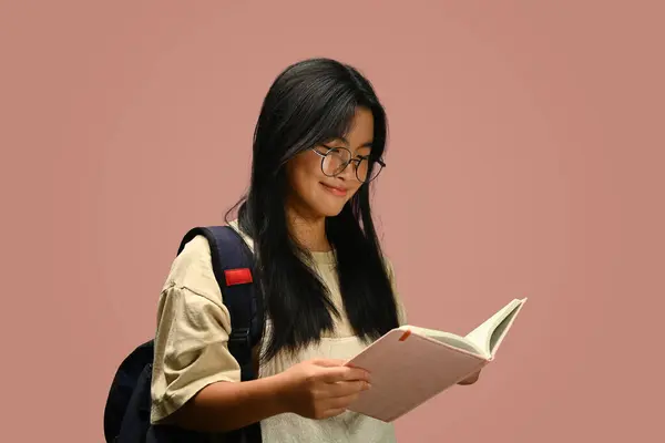 Uśmiechnięta Azjatycka Uczennica Plecakiem Trzymająca Książkę Różowym Tle Edukacja Uczenie — Zdjęcie stockowe
