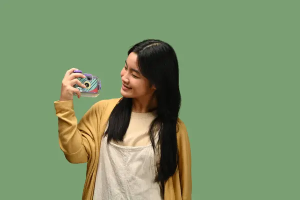 Kameralı Gülümseyen Asyalı Genç Kız Yeşil Arka Planda Yalnız Poz — Stok fotoğraf