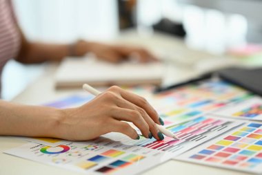 Dijital tablet kullanan ve grafik stüdyosundaki renk örneklerini seçen yaratıcı kadın..