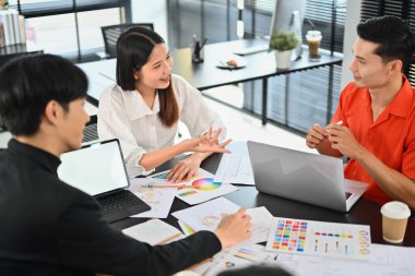 Erkek ve kadın yaratıcı tasarımcı ofisteki yeni iç dizayn yenileme projeleri için beyin fırtınası yapıyorlar..