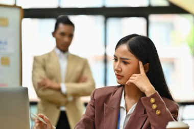 Stresli kadın çalışanlar iş sonuçlarından memnun değil ve arka planda katı bir patron var..