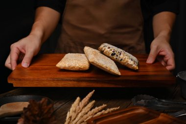 Ahşap tepside ev yapımı tempeh taşıyan önlük giyen bir adam. En sağlıklı alternatif bitki proteini..