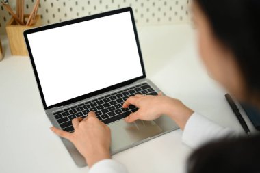 Laptop klavyesinde yazı yazan genç kadınların omuz manzarasına bakın. Reklam metniniz için boş ekran.