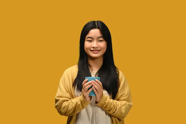 Happy Asian Girl Sweter Holding Cup Hot Drink Yellow Background — Stok Foto