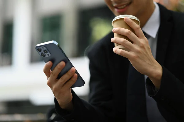 Uśmiechnięty Męski Pracownik Pijący Kawę Korzystający Smartfona Siedząc Schodach Biurowca — Zdjęcie stockowe