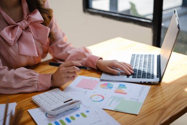 İş kadını, pazarlama verilerini, istatistikleri, mali sonuçları ofis masasında analiz ediyor.
