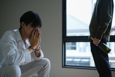 Bira şişesi tutan alkolik bir adam erkek arkadaşıyla kavga ediyor. LGBTQ ilişkisi, alkol bağımlılığı kavramı.