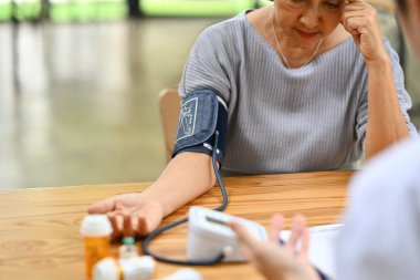 Klinikteki yüksek tansiyon seviyesiyle ilgili endişeleri olan orta yaşlı kadın. Sağlık hizmetleri kavramı.