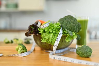 Taze sebzeler, mezura ve mutfak masasında bir bardak yeşil smoothie. Sağlıklı yaşam tarzı, diyet ve kilo kaybı kavramı.