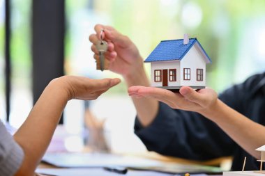 Emlakçı, sözleşmeyi imzaladıktan sonra evin anahtarlarını yeni sahibine veriyor. Gayrimenkul, mortgage, kredi ve sigorta.