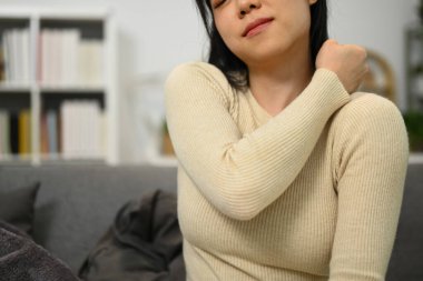 Omzu ve boynu ağrıyan genç bir kadın boynuna dokunuyor. Sağlık ve Tıp Konsepti.