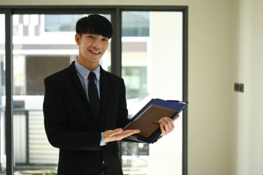 Kendine güvenen emlakçı yeni evinde teklif sunmaya hazır bekliyor. Gayrimenkul, kredi ve emlak yatırım kavramı.