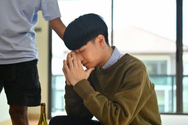 Ağlayan adamı teselli eden merhametli arkadaşın eli. Depresyon ve zihinsel sağlık kavramı.