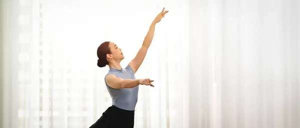 Young graceful woman practicing in bright rehearsal room. Art, people motion, flexibility and inspiration concept.