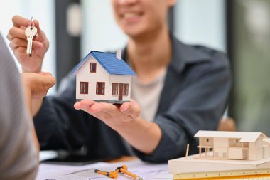 Emlakçı, satış müdürü satış sözleşmesini imzaladıktan sonra müşteriye anahtarları veriyor. Mülk almak, emlak, kredi.