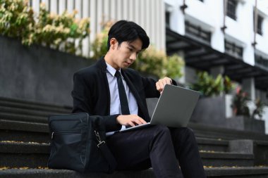 Ofis binasına karşı dizüstü bilgisayarda iş sorunları çözmekle meşgul bir erkek işçi, acele et..