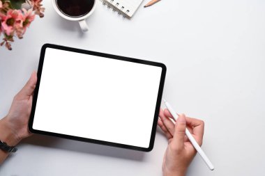 Beyaz ofis masasında dijital tablet kullanan bir kadın. Reklam metniniz için boş ekran.