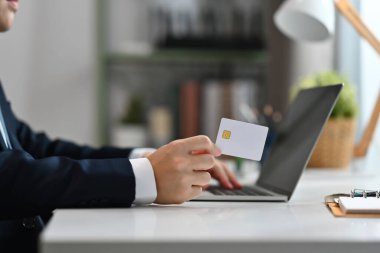 Elinde plastik kartla internetten ödeme yapan vurulan bir işadamı. E-ticaret, internet bankacılığı kavramı.