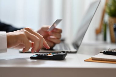 Masrafları ve kredi kartlarının borçlarını hesaplayan bir adam. E-ticaret, mali planlama ve harcamalar.