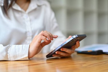 Akıllı telefondan mesaj atan genç bir kadın. İletişim, teknoloji ve iş hayatı konsepti.