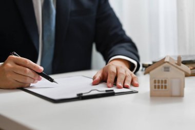 Erkek emlakçı, müşteri için sözleşme hazırlıyor. Gayrimenkul, kredi ve emlak yatırım kavramı.