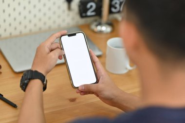 İş yerinde akıllı telefon kullanarak omzunun üstünden bak. Reklam metniniz için boş ekran.