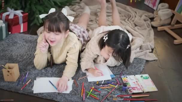Веселі Маленькі Сестри Роблять Вітальні Листівки Новий Рік Різдво Лежачи — стокове відео