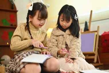 Noel tatili ve yeni yıl boyunca oturma odasında tebrik kartı atan iki tatlı kardeş..