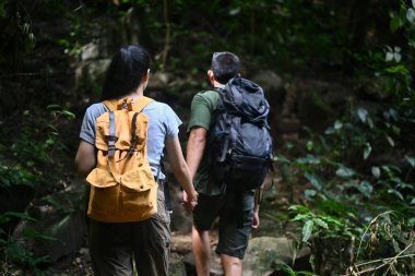Ormanda gezen ve doğayı keşfeden mutlu genç çift. Seyahat, macera ve aktif yaşam konsepti.