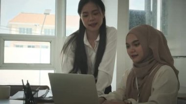 İş arkadaşı ile proje istatistiklerini tartışan tesettürlü güzel Müslüman iş kadınının yavaş çekimleri.
