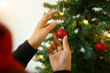 Atmosferik festival odasındaki Noel ağacını süsleyen kadını kapatın. Tatil hazırlama kavramı.