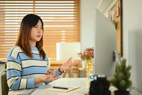 照片中的年轻亚洲女人看着电脑显示器在家里参加虚拟在线培训 — 图库照片