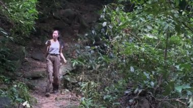 İnternet bağlantısı arayan ya da yeşil ormandaki akıllı telefonda GPS navigatör uygulaması kullanan bir kadın kaşif..